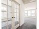 Bright living room featuring fresh paint, neutral carpet and light-filled windows and glass paneled doors at 9264 Biscay St, Commerce City, CO 80022
