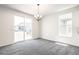 Bright room with neutral walls, gray carpet, and sliding glass door leading to the outdoor space at 9264 Biscay St, Commerce City, CO 80022
