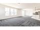 Open living space featuring large windows, fresh paint, carpet and an eat in kitchen at 9264 Biscay St, Commerce City, CO 80022
