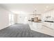 Open living area with fresh paint, neutral carpet, and an eat in kitchen with island at 9264 Biscay St, Commerce City, CO 80022