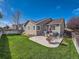 Large backyard with patio, grass, and a woodpile at 11462 Iola St, Commerce City, CO 80640
