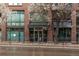 Building entrance with brick facade, glass doors, and decorative tree at 1401 Wewatta St # 311, Denver, CO 80202