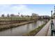Scenic riverwalk with bike trail, pedestrian bridge, and green space under a blue sky at 1401 Wewatta St # 311, Denver, CO 80202