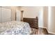 Cozy bedroom featuring a comfortable bed, wood floors, a dresser, and a closet for ample storage at 9227 Salida St, Commerce City, CO 80022