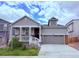Charming gray two-story home with a covered front porch and two car garage at 9227 Salida St, Commerce City, CO 80022