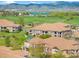 Aerial view of townhouses with lush green spaces and a community park surrounded by a mountain view at 6202 Kilmer Loop # 202, Golden, CO 80403