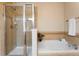 Tiled walk-in shower and separate soaking tub with decorative accents and a glass shower door at 6202 Kilmer Loop # 202, Golden, CO 80403