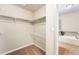Spacious walk-in closet featuring ample shelving and a rod system, adjoined to a bathroom with soaking tub at 6202 Kilmer Loop # 202, Golden, CO 80403