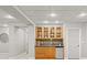 Basement bar area featuring custom glass cabinets, tiled backsplash, and a mini fridge at 5925 Zinnia Ct, Arvada, CO 80004