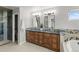 Double vanity bathroom with granite counters, custom cabinetry, and walk-in shower at 5925 Zinnia Ct, Arvada, CO 80004
