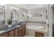 Bright bathroom with double vanity, granite counters, soaking tub, and neutral tiled accents at 5925 Zinnia Ct, Arvada, CO 80004