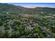 Aerial view showcasing a neighborhood with mountain views and lush green trees surrounding the homes at 1931 Foothills Rd, Golden, CO 80401