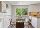 Bright dining area with a glass-top table and views of lush greenery through the window at 1931 Foothills Rd, Golden, CO 80401