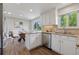Modern kitchen with white cabinets, granite countertops, stainless steel appliances, and natural light at 1931 Foothills Rd, Golden, CO 80401