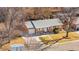 Aerial view of brick home with mature trees, grey roof and attached garage at 6359 Brooks Dr, Arvada, CO 80004