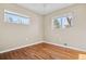 Bedroom featuring hardwood floors, neutral walls and two large windows at 6359 Brooks Dr, Arvada, CO 80004