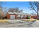 Charming red brick single story home featuring a attached garage, green front lawn, and mature trees at 6359 Brooks Dr, Arvada, CO 80004