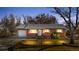 Charming single-story brick home at dusk with well-manicured lawn, white trim and attached one-car garage at 6359 Brooks Dr, Arvada, CO 80004