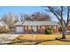Charming single-story brick home with well-manicured lawn, white trim and attached one-car garage at 6359 Brooks Dr, Arvada, CO 80004