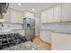 Well-lit kitchen featuring granite countertops, stainless steel appliances, and bright white cabinetry at 6359 Brooks Dr, Arvada, CO 80004