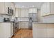 Bright kitchen featuring white cabinets, stainless steel appliances, and subway tile backsplash at 6359 Brooks Dr, Arvada, CO 80004