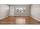 Living room with gleaming hardwood floors and white trim, complemented by a large picture window at 6359 Brooks Dr, Arvada, CO 80004
