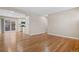 Living room with hardwood floors, flows seamlessly into a kitchen with white cabinets and stainless appliances at 6359 Brooks Dr, Arvada, CO 80004