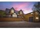 Exterior of a wooden home with a gravel driveway under a vibrant, colorful sunset sky at 220 Wark Ave, Berthoud, CO 80513