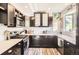 Well-lit kitchen with dark cabinets, stainless steel appliances, and decorative touches that creates a warm and inviting atmosphere at 220 Wark Ave, Berthoud, CO 80513