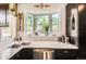 Sunlit kitchen featuring white countertops, stainless steel appliances and a charming bay window overlooking the lush greenery outside at 220 Wark Ave, Berthoud, CO 80513