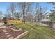 Spacious backyard with a lush lawn, flower beds, and mature trees providing privacy at 6470 S Oak Ct, Littleton, CO 80127