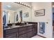 Bathroom features double sinks, granite countertop, and framed mirror with vanity lighting at 6470 S Oak Ct, Littleton, CO 80127