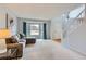 Bright living room with neutral carpet, a large bay window, and an open staircase leading to the upper level at 6470 S Oak Ct, Littleton, CO 80127