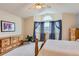 Bright main bedroom featuring neutral carpet, ceiling fan, and a large window with curtains at 6470 S Oak Ct, Littleton, CO 80127