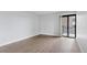 Bright empty room featuring wood floors and sliding glass doors to the balcony at 480 S Marion Pkwy # 802, Denver, CO 80209