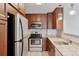 Well-equipped kitchen featuring stainless steel appliances, wood cabinets, and granite countertops at 480 S Marion Pkwy # 802, Denver, CO 80209