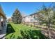 Beautiful backyard with lush green grass, trees, and a wooden fence surrounding the property at 19681 E 59Th Pl, Aurora, CO 80019