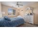 Bright bedroom with a large window, a ceiling fan, and a white dresser with mirror at 19681 E 59Th Pl, Aurora, CO 80019