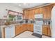 Bright kitchen with stainless steel appliances, tile backsplash, granite countertops, and ample wooden cabinetry at 19681 E 59Th Pl, Aurora, CO 80019