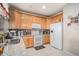 Well-equipped kitchen featuring granite countertops, stainless steel appliances, wooden cabinets, and tile backsplash at 19681 E 59Th Pl, Aurora, CO 80019
