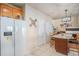 Spacious kitchen with white appliances, tile flooring, and a large island with seating, perfect for Gathering gatherings at 19681 E 59Th Pl, Aurora, CO 80019