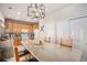 Bright kitchen featuring a large island with seating, granite countertops, wooden cabinets, and modern lighting at 19681 E 59Th Pl, Aurora, CO 80019