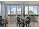 Enclosed balcony showcasing a charming seating area with a table and wrought iron chairs at 3465 S Poplar St # 506, Denver, CO 80224