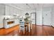 White cabinets, stainless appliances, and a modern light fixture over the hardwood floor kitchen at 3465 S Poplar St # 506, Denver, CO 80224