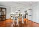 Kitchen featuring a dining table, white cabinets, modern appliances, and hardwood floors at 3465 S Poplar St # 506, Denver, CO 80224