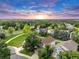 Aerial view of neighborhood with homes, trees, green spaces, and colorful sunset at 4112 Brandon Ave, Broomfield, CO 80020