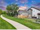 Beautiful backyard of home with wooden fence, green grass, and walkway at 4112 Brandon Ave, Broomfield, CO 80020