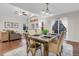 Elegant dining area with modern lighting, hardwood floors, seating for four, and views into the cozy living space at 4112 Brandon Ave, Broomfield, CO 80020