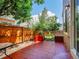 Private fenced-in backyard featuring a red stone patio with mature landscaping at 1288 S Beeler Ct, Denver, CO 80247