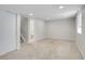 A finished basement with neutral carpet, recessed lighting, and access to a bathroom and stairway at 1288 S Beeler Ct, Denver, CO 80247